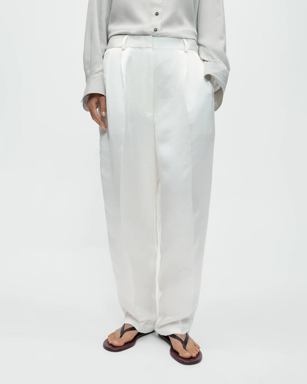 Model wearing CORDERA Satin Masculine Barrel Pants in white with an oversized barrel silhouette and sharp front crease.