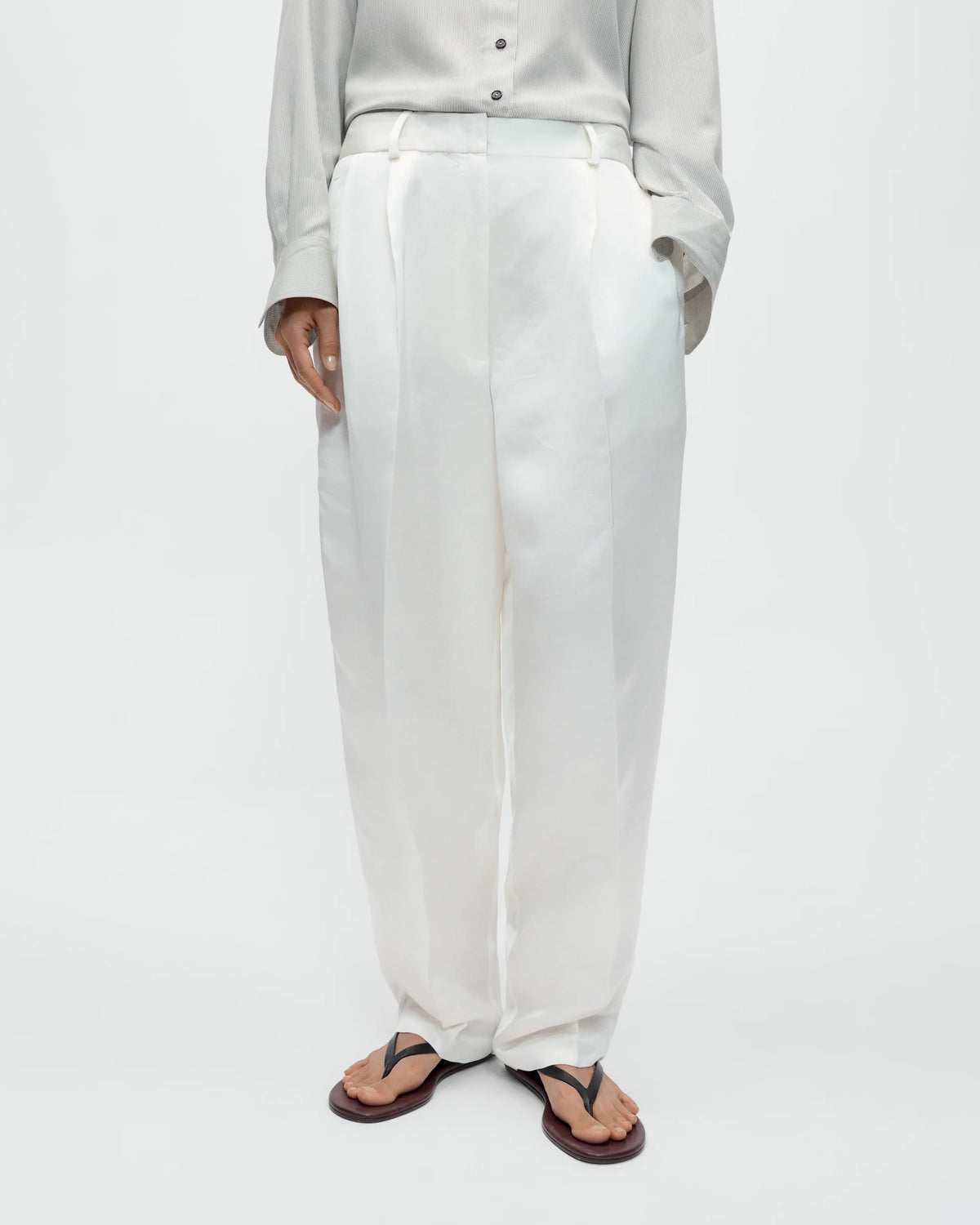 Model wearing CORDERA Satin Masculine Barrel Pants in white with an oversized barrel silhouette and sharp front crease.