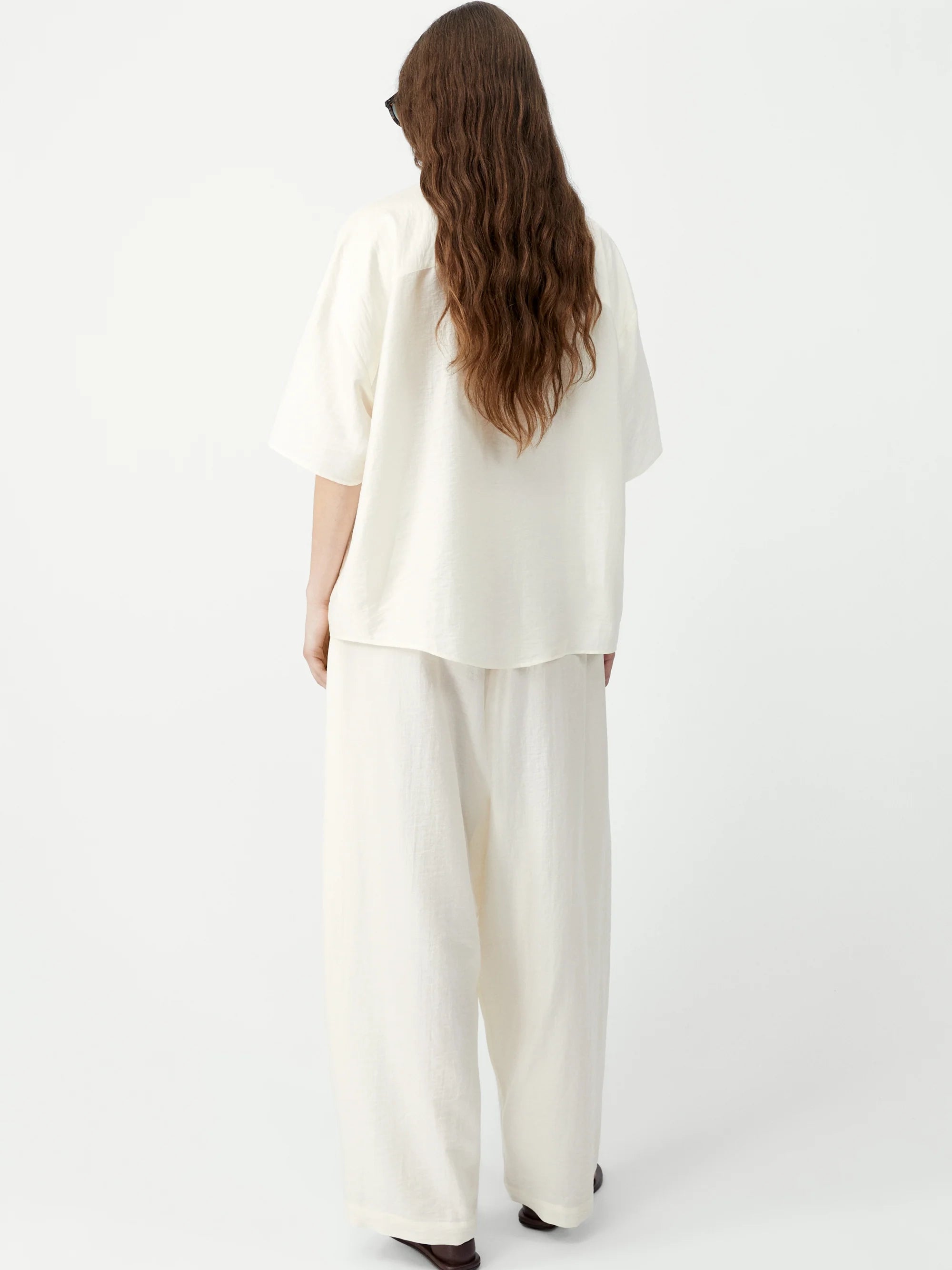 Person wearing a white outfit on a plain background