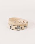 Beige suede belt with polished silver buckle, rivet detailing and wrapped metal keeper by Déhanche.
