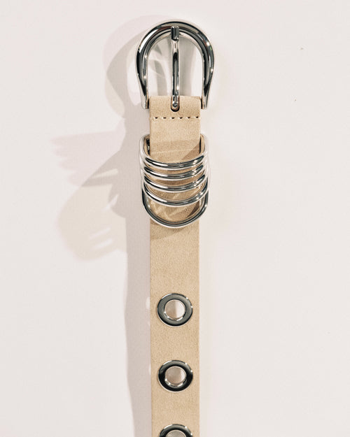Beige suede belt with polished silver buckle, rivet detailing and wrapped metal keeper by Déhanche.