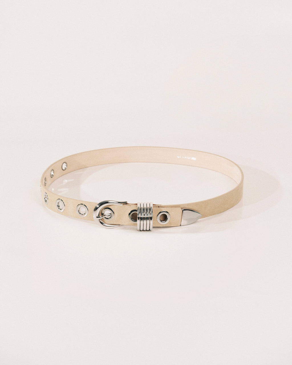 Beige suede belt with polished silver buckle, rivet detailing and wrapped metal keeper by Déhanche.