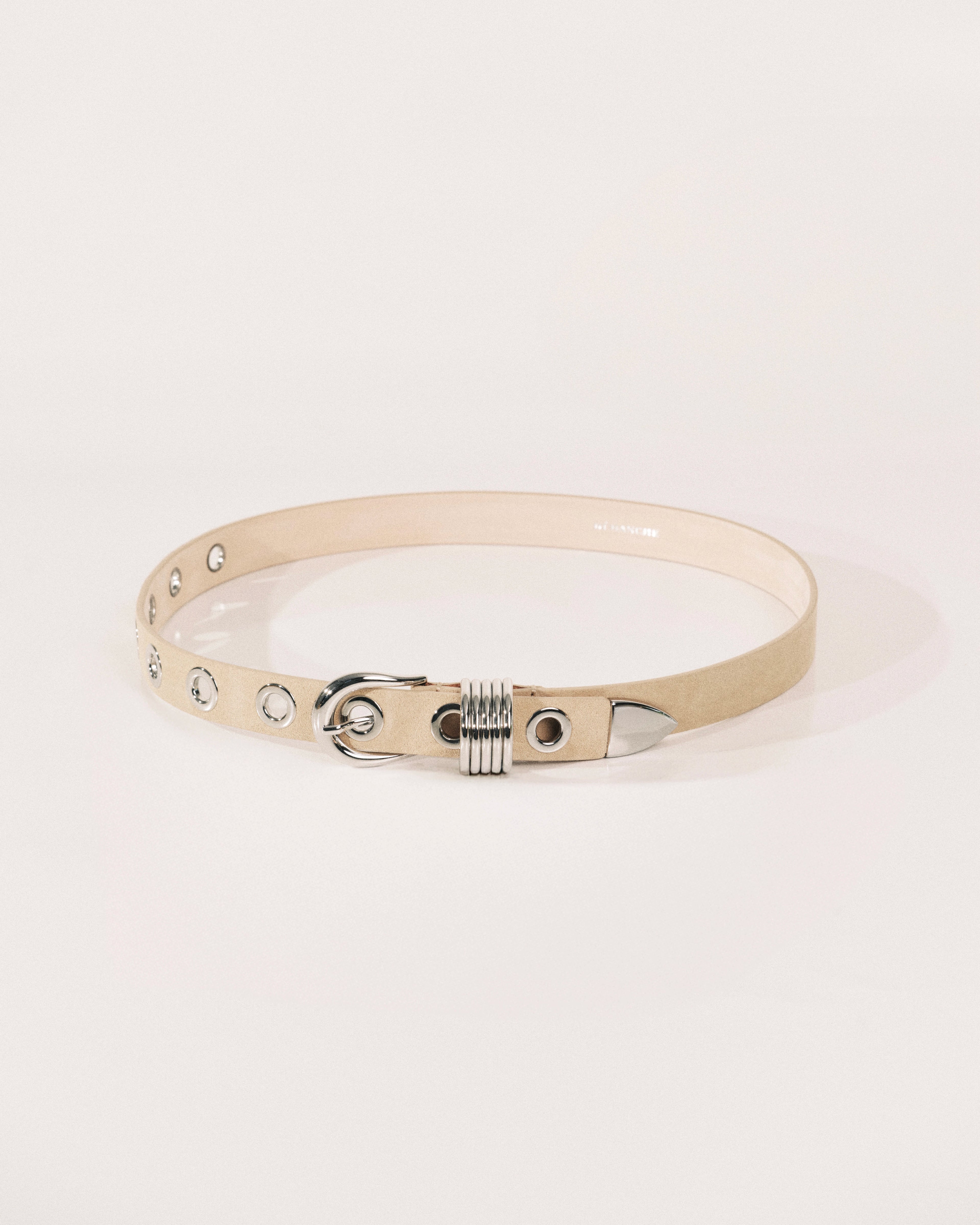 Beige suede belt with polished silver buckle, rivet detailing and wrapped metal keeper by Déhanche.