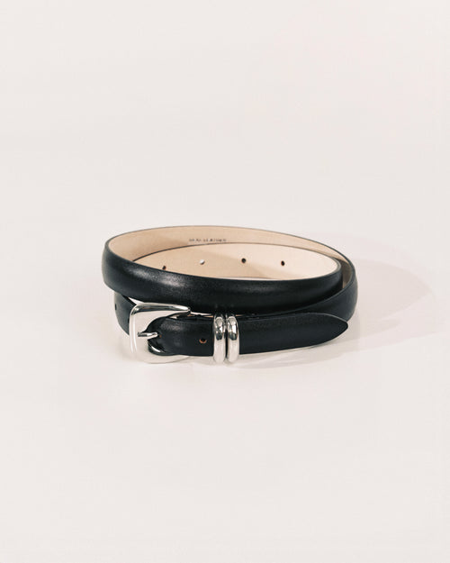 Black leather belt by Déhanche with sculptural silver-tone buckle and curved metal keeper.