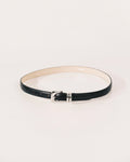 Black leather belt by Déhanche with sculptural silver-tone buckle and curved metal keeper.