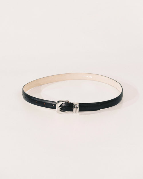 Black leather belt by Déhanche with sculptural silver-tone buckle and curved metal keeper.