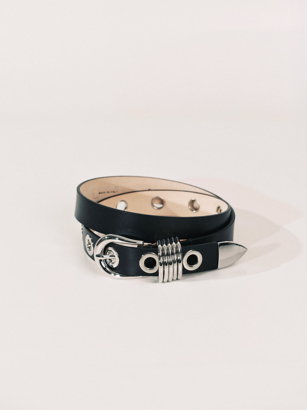 Black leather belt with silver accents on a light gray background
