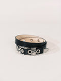 Black leather belt with silver accents on a light gray background