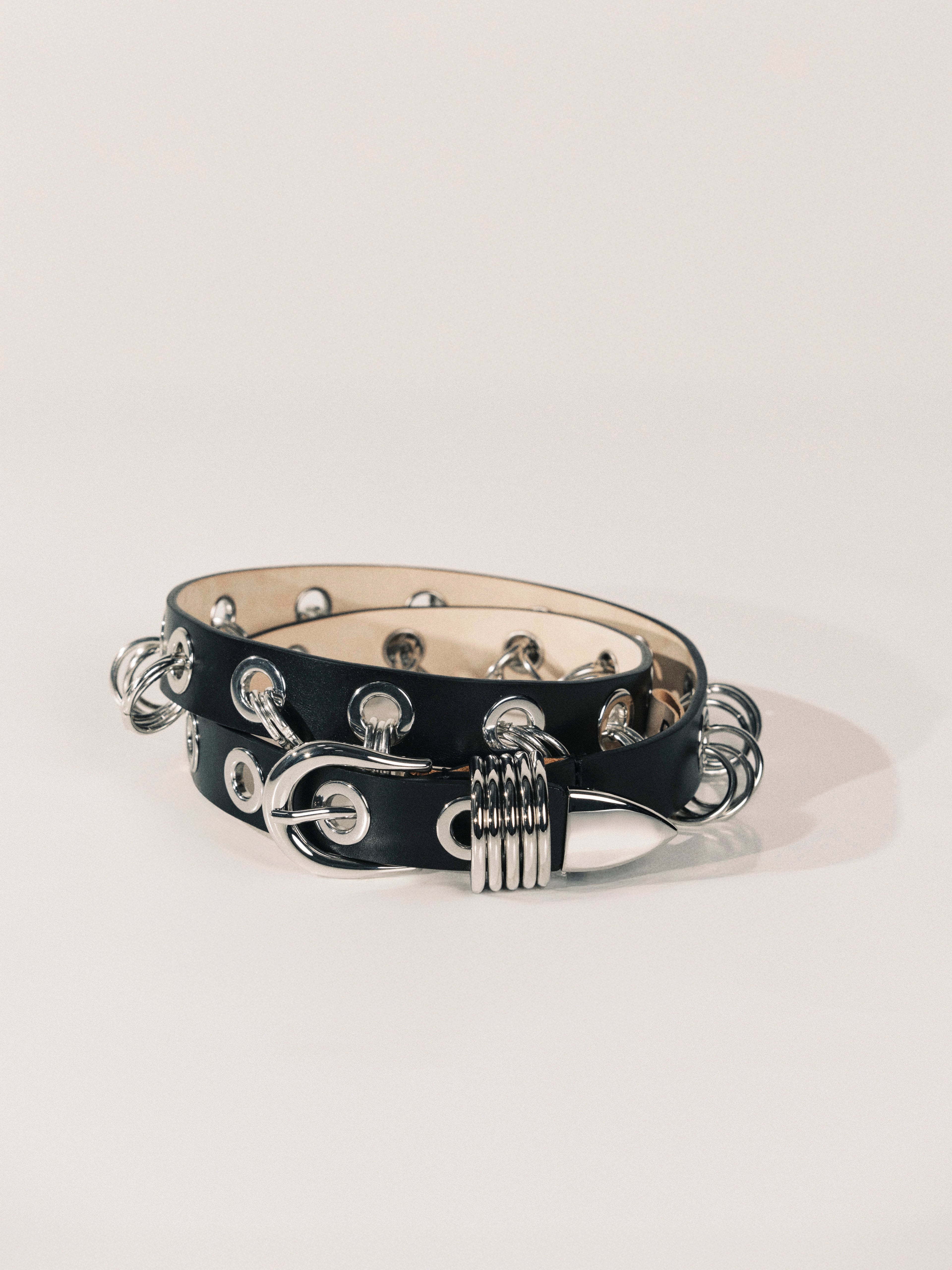 Black leather bracelet with silver metal accents on a white background