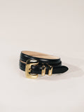 Black leather belt with a gold buckle on a light gray background