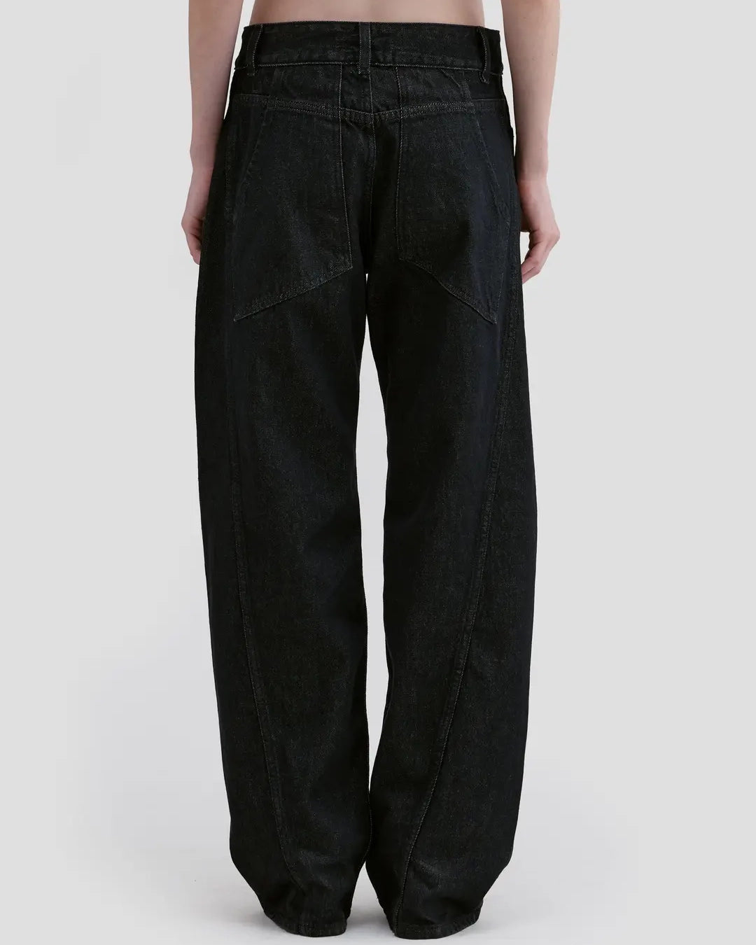 Back detail view of model wearing Eckhaus Latta Bend Jean in black rinse with a loose bowed leg and twisted side seams.