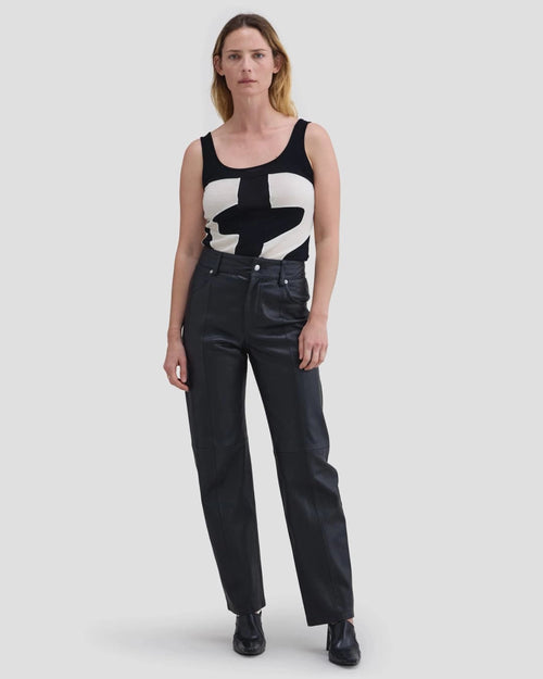 Model wearing Eckhaus Latta Cruising Jean in Dusk with a high-rise straight leg in black leather.