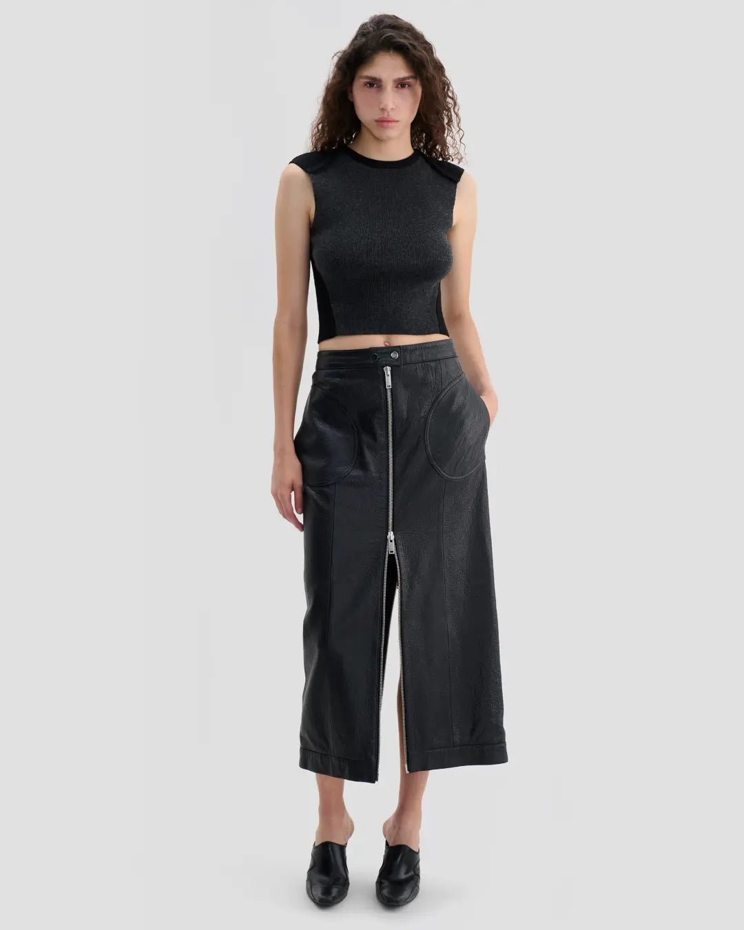 Model wearing Eckhaus Latta Cruising Skirt in dusk with a high-rise, straight silhouette and center-front zip closure.