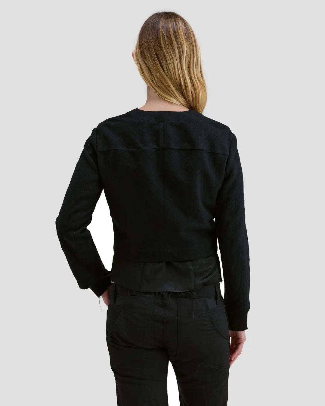 Back view of model wearing Eckhaus Latta Double Jacket in coal with a cropped, structured shape and layered construction.