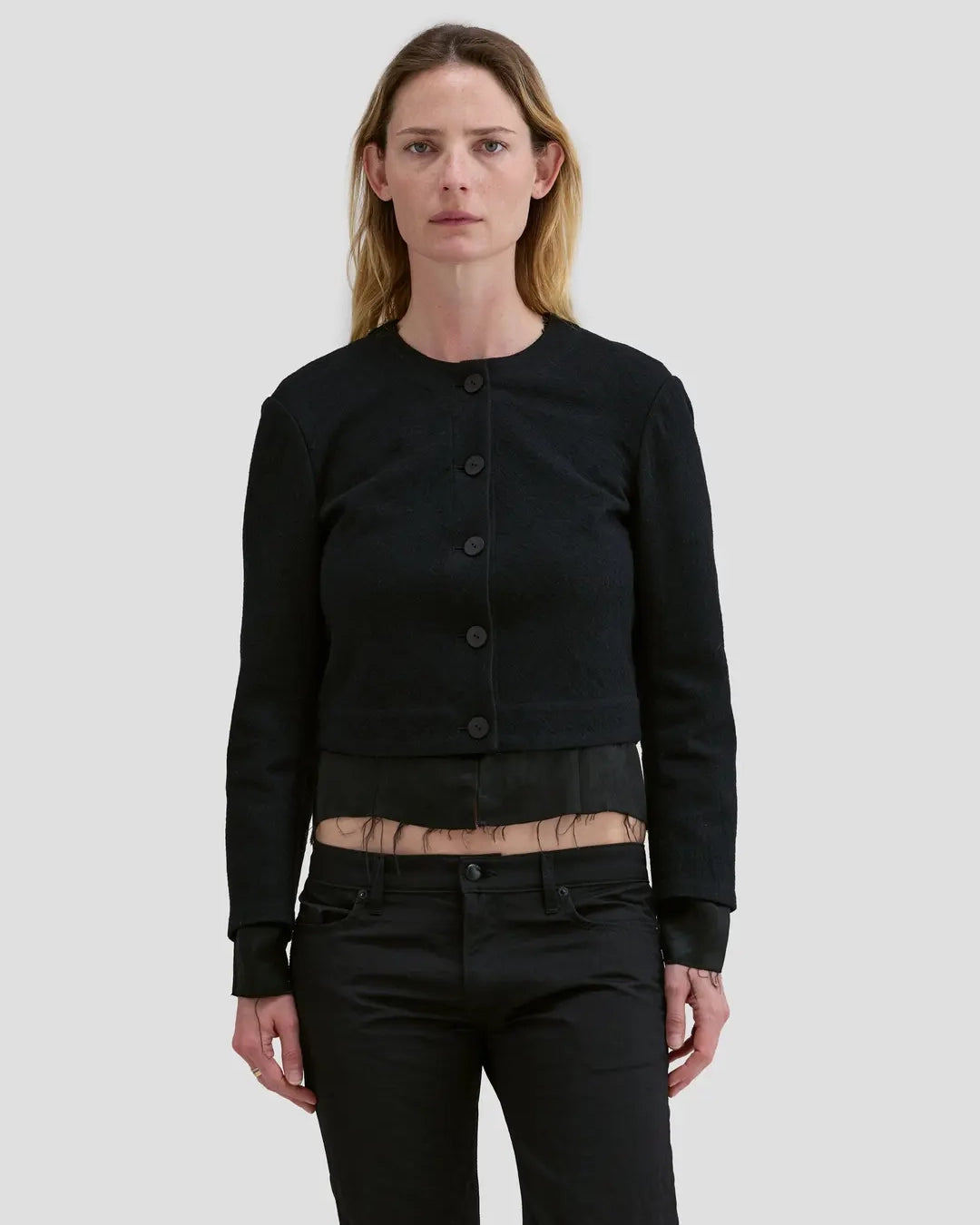 Model wearing Eckhaus Latta Double Jacket in coal with a cropped, structured shape and layered construction.