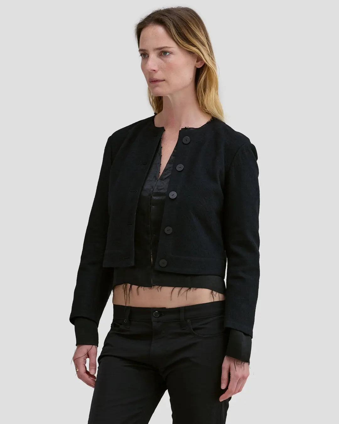 Model wearing Eckhaus Latta Double Jacket in coal with a cropped, structured shape and layered construction.