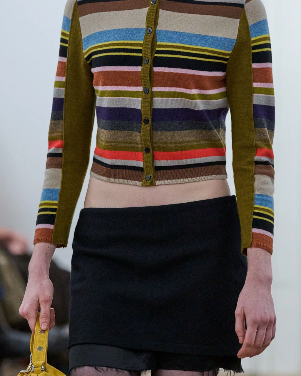 Detail view of model wearing Eckhaus Latta Double Skirt in black with a layered mini silhouette and raw underlayer hem.