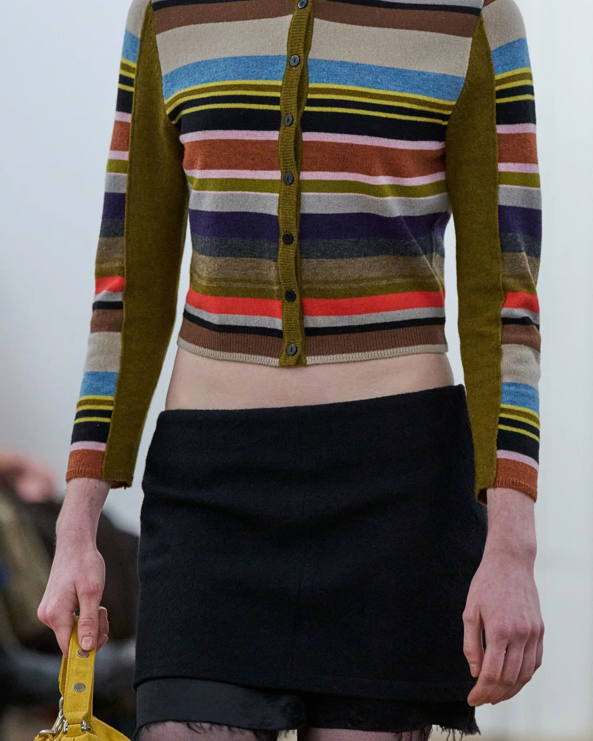Detail view of model wearing Eckhaus Latta Double Skirt in black with a layered mini silhouette and raw underlayer hem.