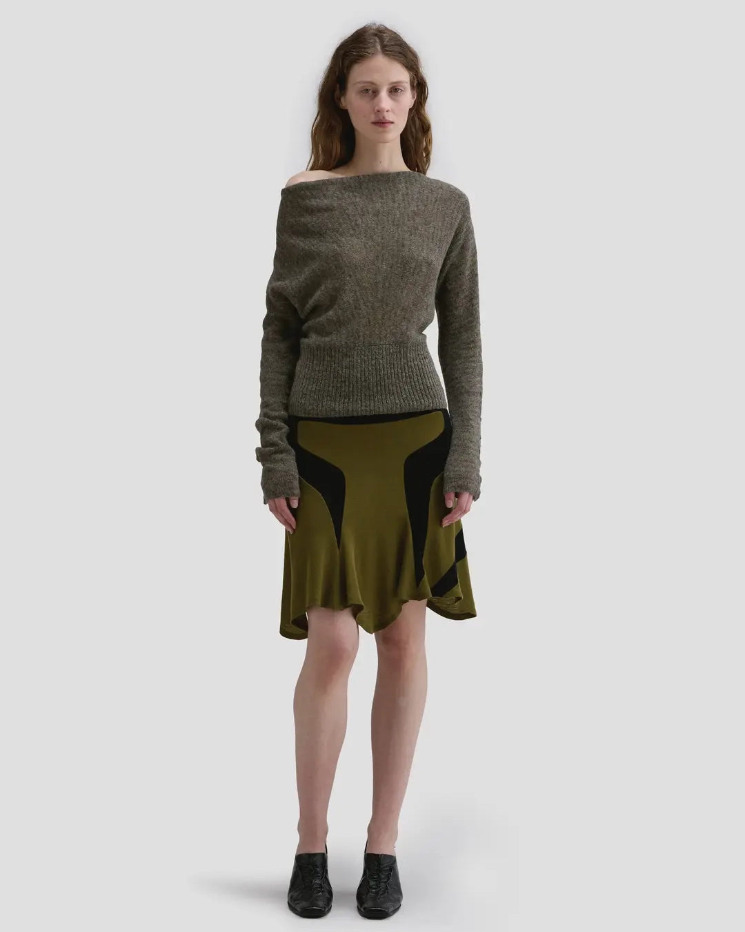 Model wearing the Eckhaus Latta Grid Sweater in fern with a cowl neckline and buttoned sleeves.