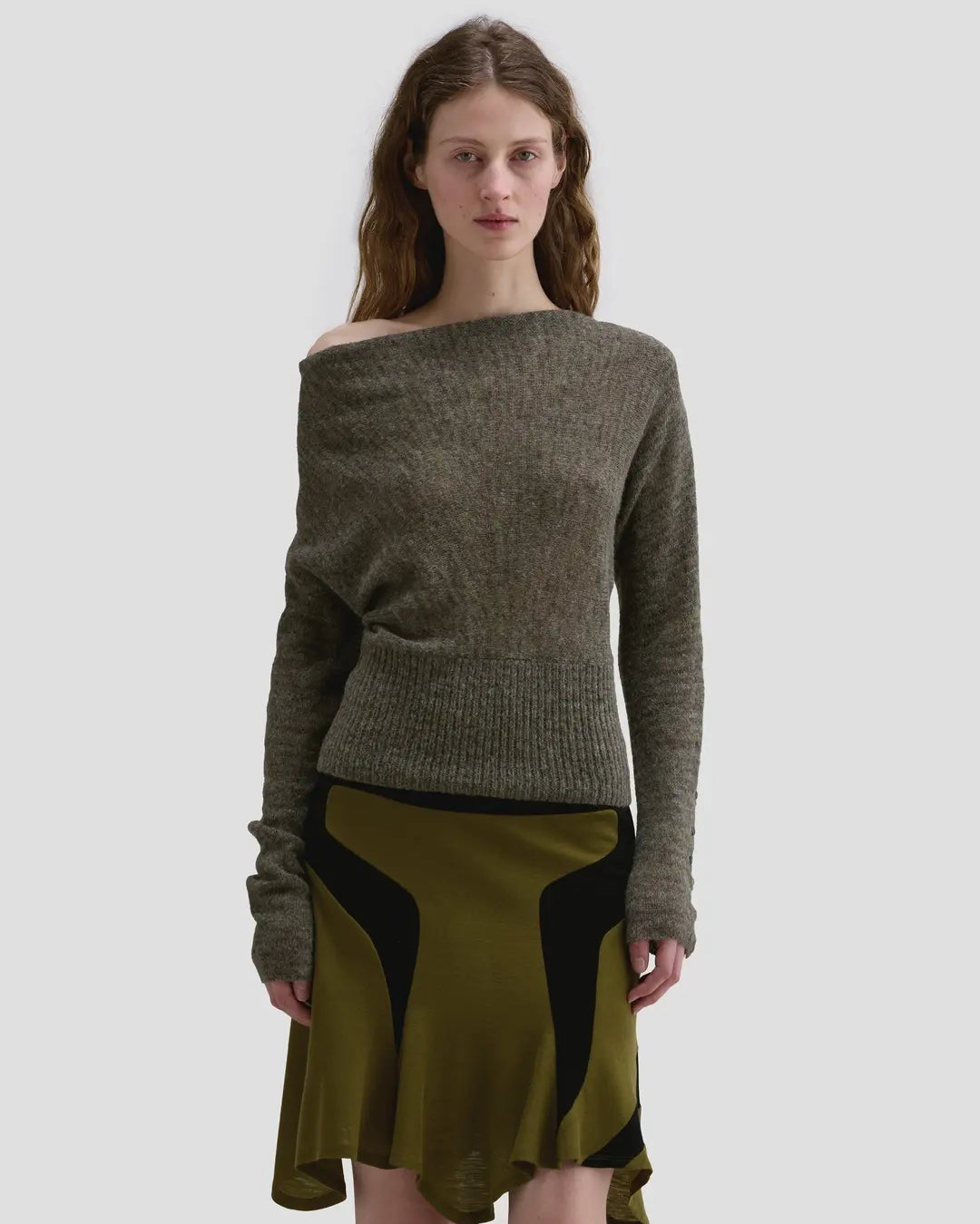Model wearing the Eckhaus Latta Grid Sweater in fern with a cowl neckline and buttoned sleeves.