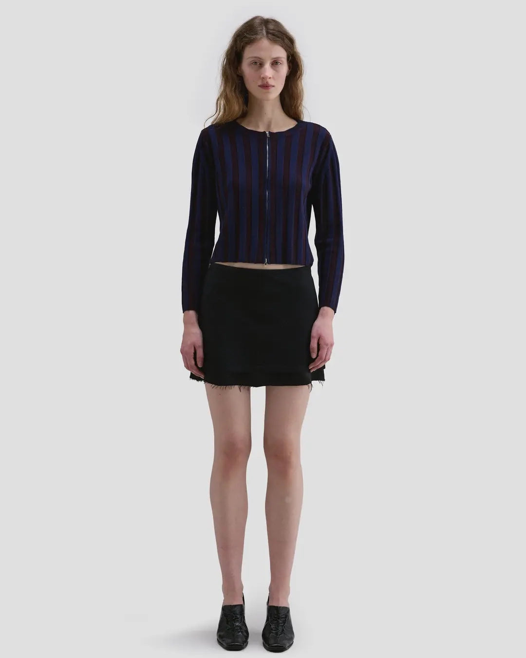 Model wearing the Eckhaus Latta Keyboard Zip Cardigan in port with a fitted shape, contrast stripes and front zip.