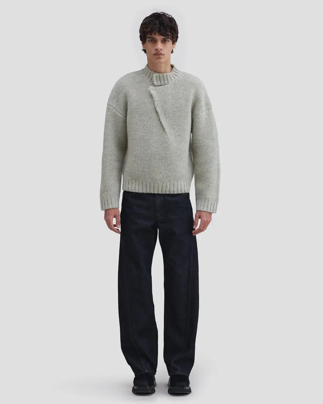 Model wearing Eckhaus Latta Roving Pullover in dove with a relaxed fit and asymmetrical Henley collar.