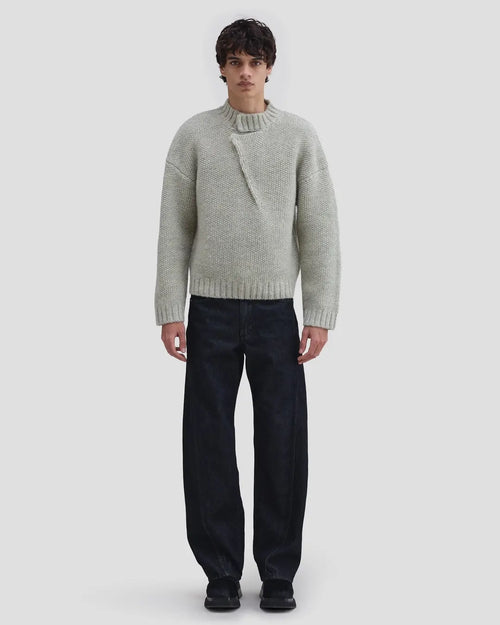 Model wearing Eckhaus Latta Roving Pullover in dove with a relaxed fit and asymmetrical Henley collar.