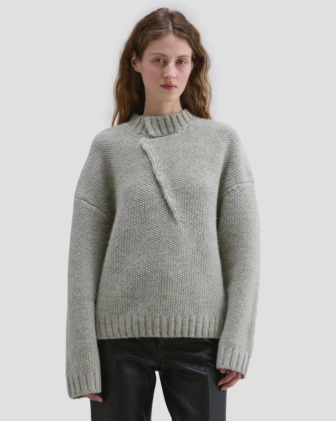 Model wearing Eckhaus Latta Roving Pullover in dove with a relaxed fit and asymmetrical Henley collar.