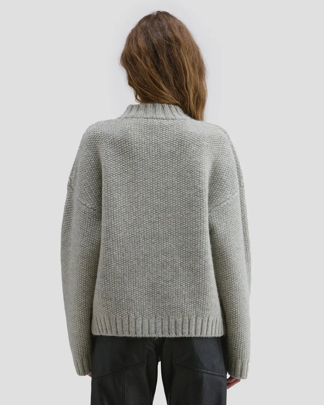 Back view of model wearing Eckhaus Latta Roving Pullover in dove with a relaxed fit and asymmetrical Henley collar.