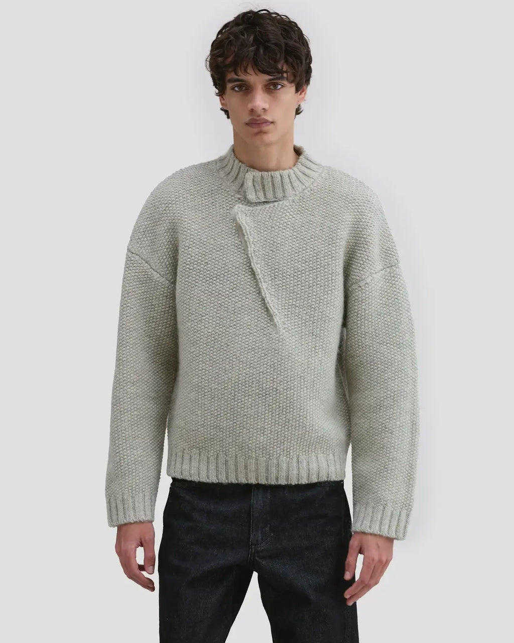 Model wearing Eckhaus Latta Roving Pullover in dove with a relaxed fit and asymmetrical Henley collar.