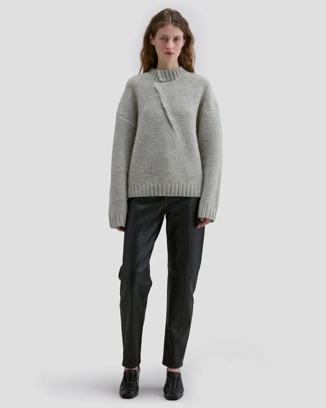 Model wearing Eckhaus Latta Roving Pullover in dove with a relaxed fit and asymmetrical Henley collar.