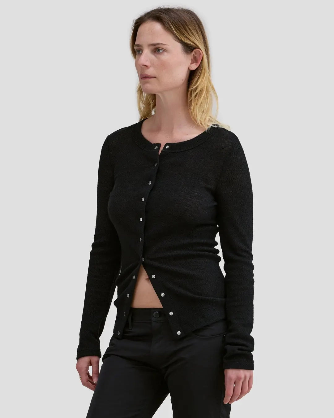 Model wearing Eckhaus Latta Scrunch Cardigan in black with a slim fit and nickel snap closures.