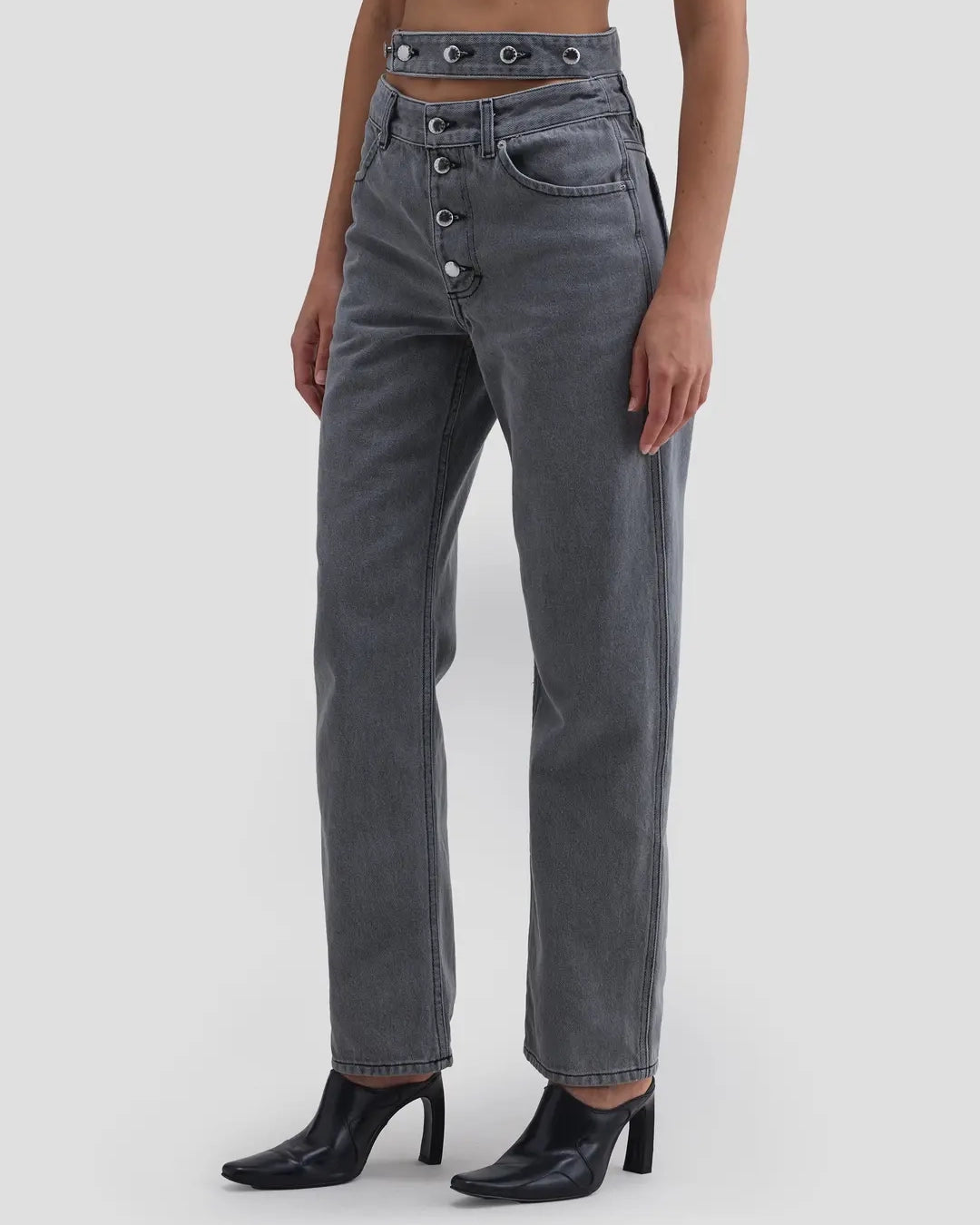 Detail view of model wearing Eckhaus Latta Shadow Jean in cement with a high-rise, slightly tapered fit and double waistband.
