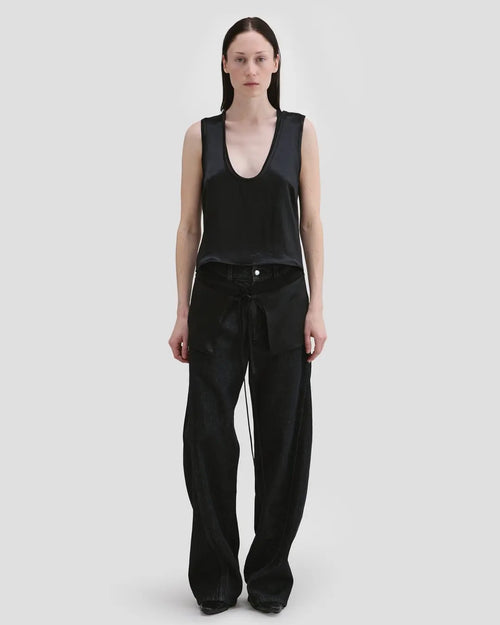 Model wearing Eckhaus Latta Zephyr Tank in oil with a low neckline and front waist peplum.
