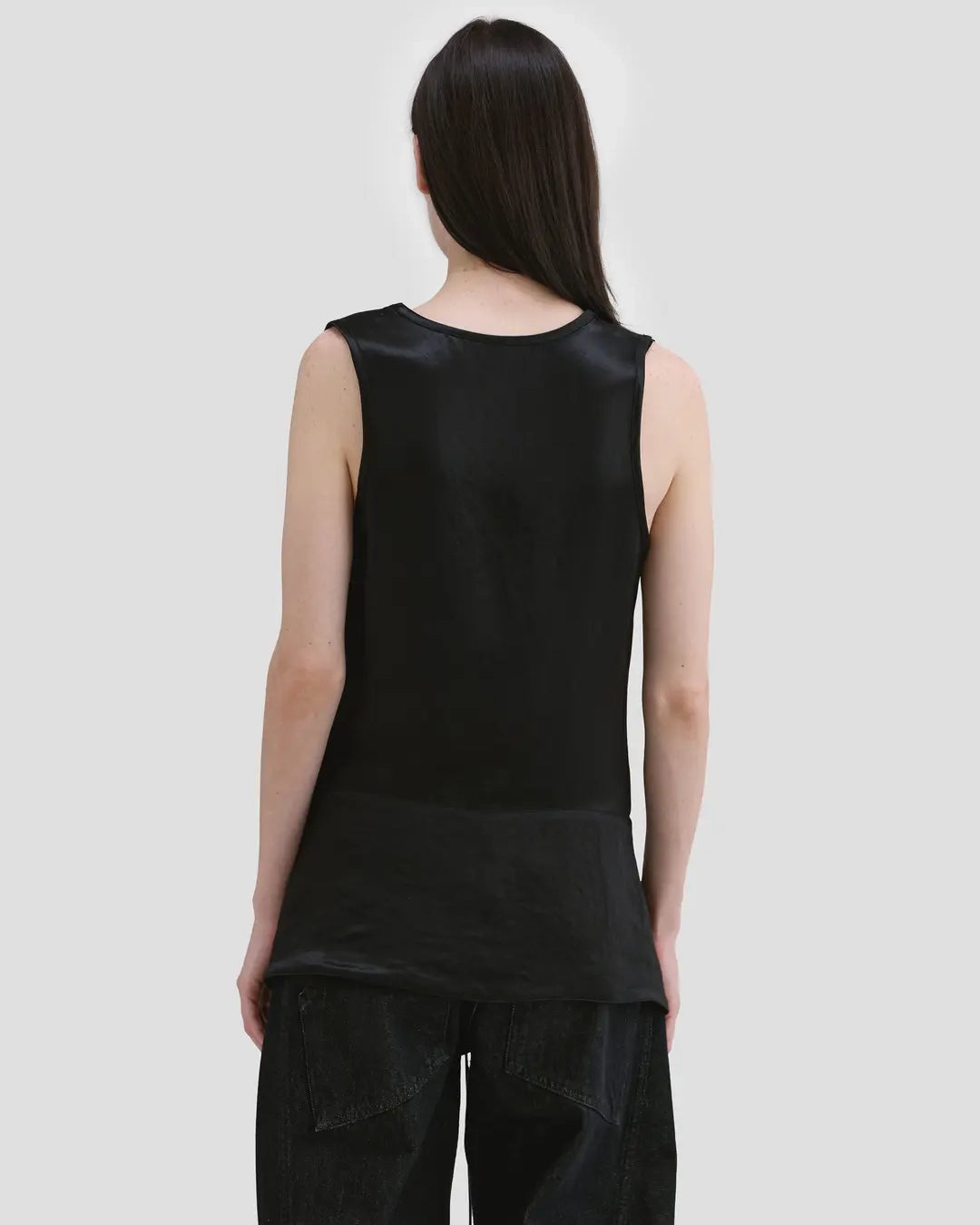 Back view of model wearing Eckhaus Latta Zephyr Tank in oil with a low neckline and front waist peplum.
