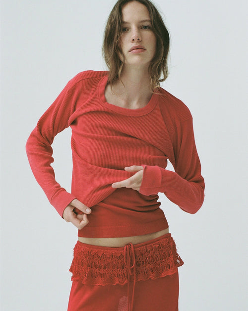 Model wearing EMILY DAWN LONG Ash Ruffle Skirt in Rosso Corsa with a fluid, ruffled silhouette.
