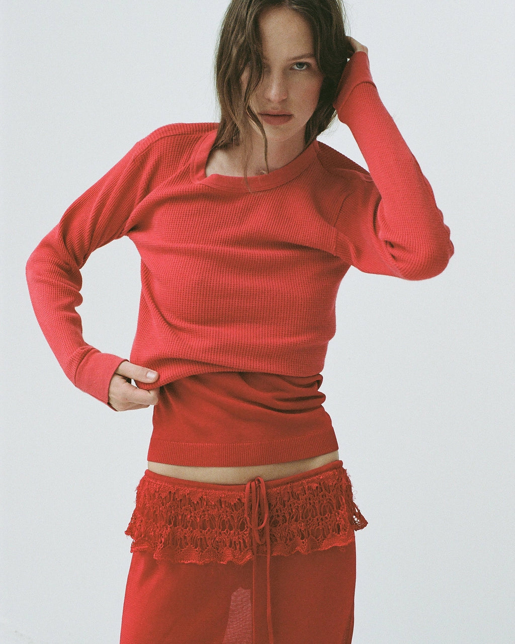 Model wearing EMILY DAWN LONG Ash Ruffle Skirt in Rosso Corsa with a fluid, ruffled silhouette.