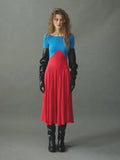 Model wearing red and blue color-block midi dress by EMILY DAWN LONG with a boat neckline, bracelet-length sleeves and full gathered skirt.