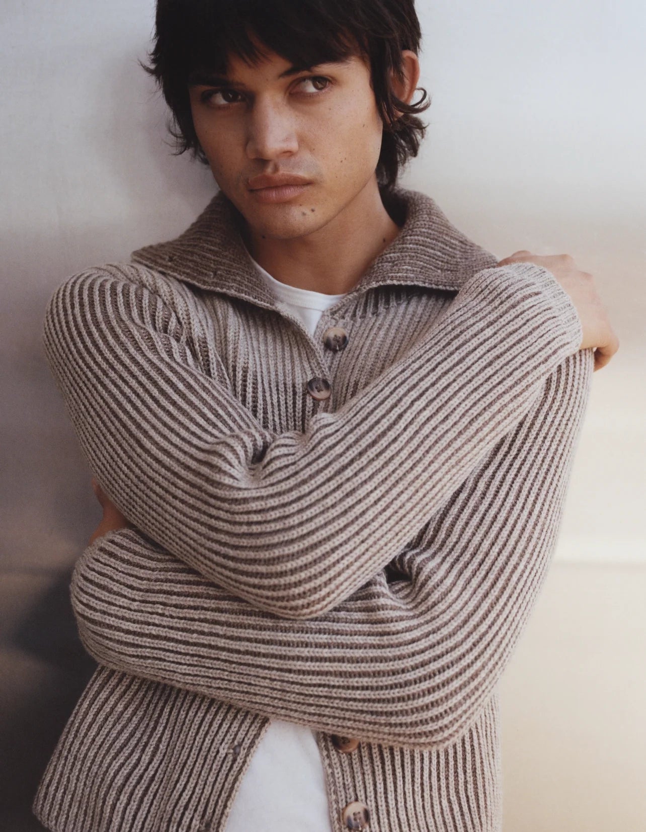 Person wearing a striped sweater against a plain background