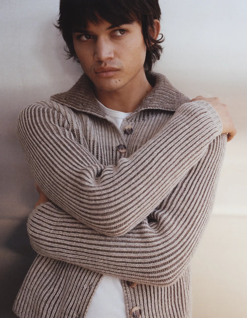 Person wearing a striped sweater against a plain background