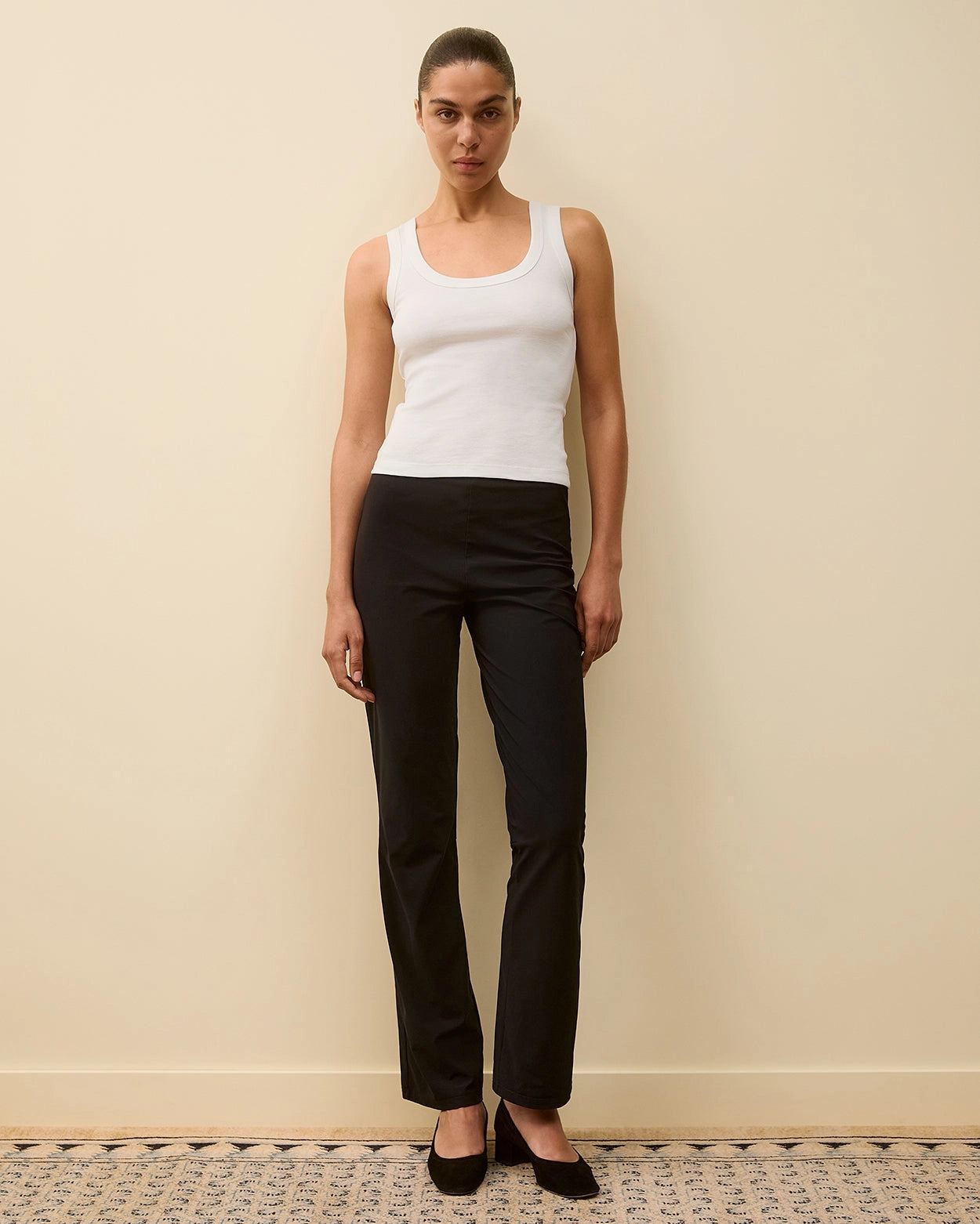 Model wearing Hillie Tank in White by FLORE FLORE, a fitted tank in organic cotton jersey with a scoop neckline.