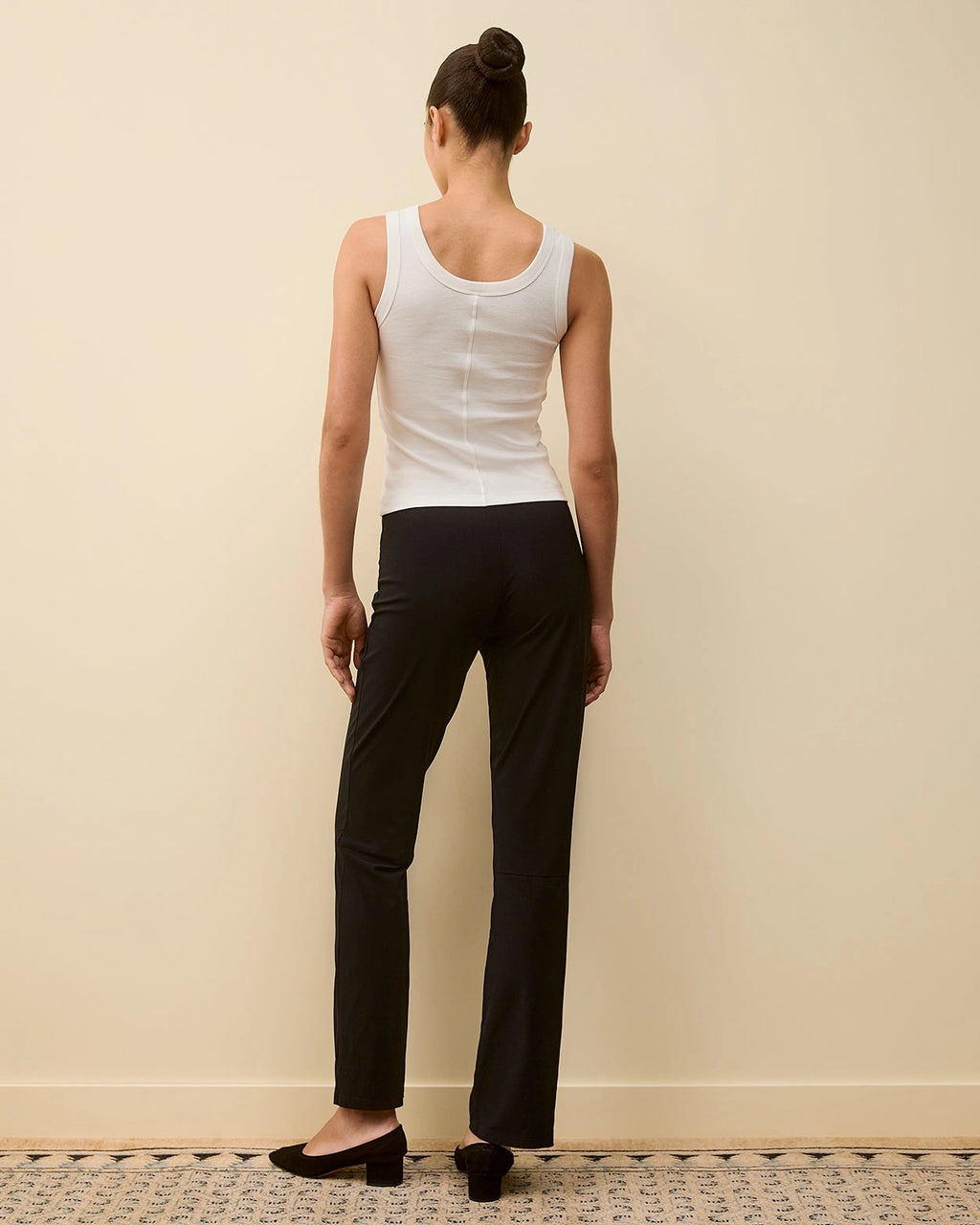 Model wearing the Hillie Tank in White by FLORE FLORE, a fitted tank in organic cotton jersey with a scoop neckline.