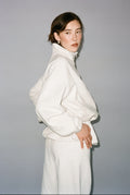 Person wearing a white outfit against a plain background