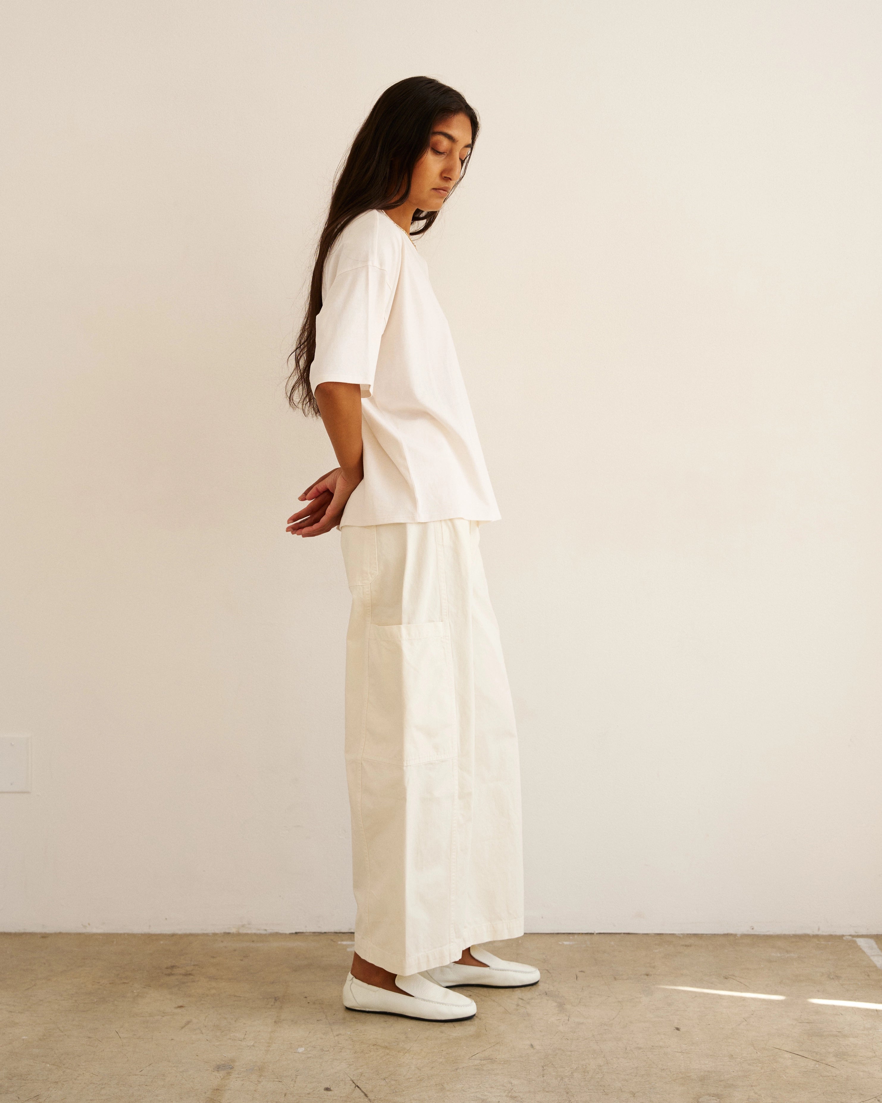 Side view of model wearing The Baggy Painter Crop in Ecru by Jamie Haller with a white oversized T-shirt.