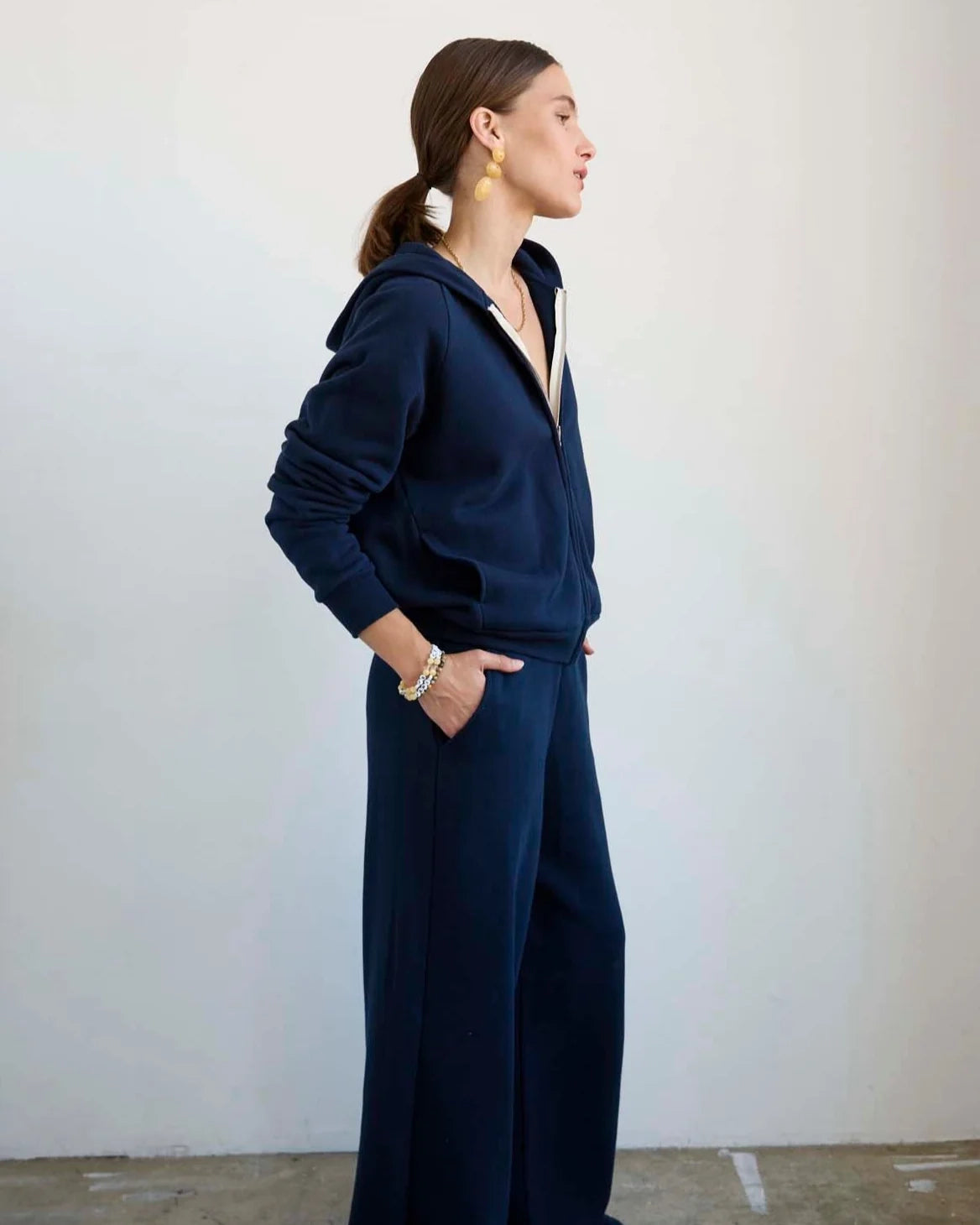 Side view of model wearing Jamie Haller Bird Hoodie in navy.