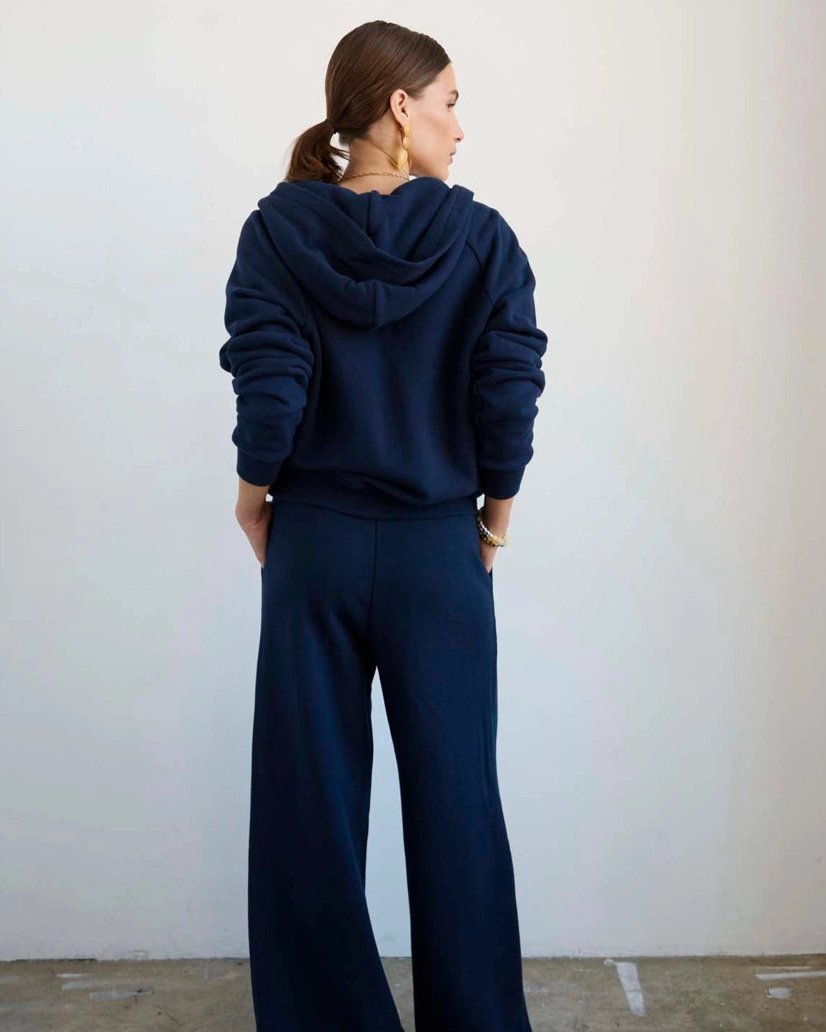 Back view of model wearing Jamie Haller Bird Hoodie in navy.