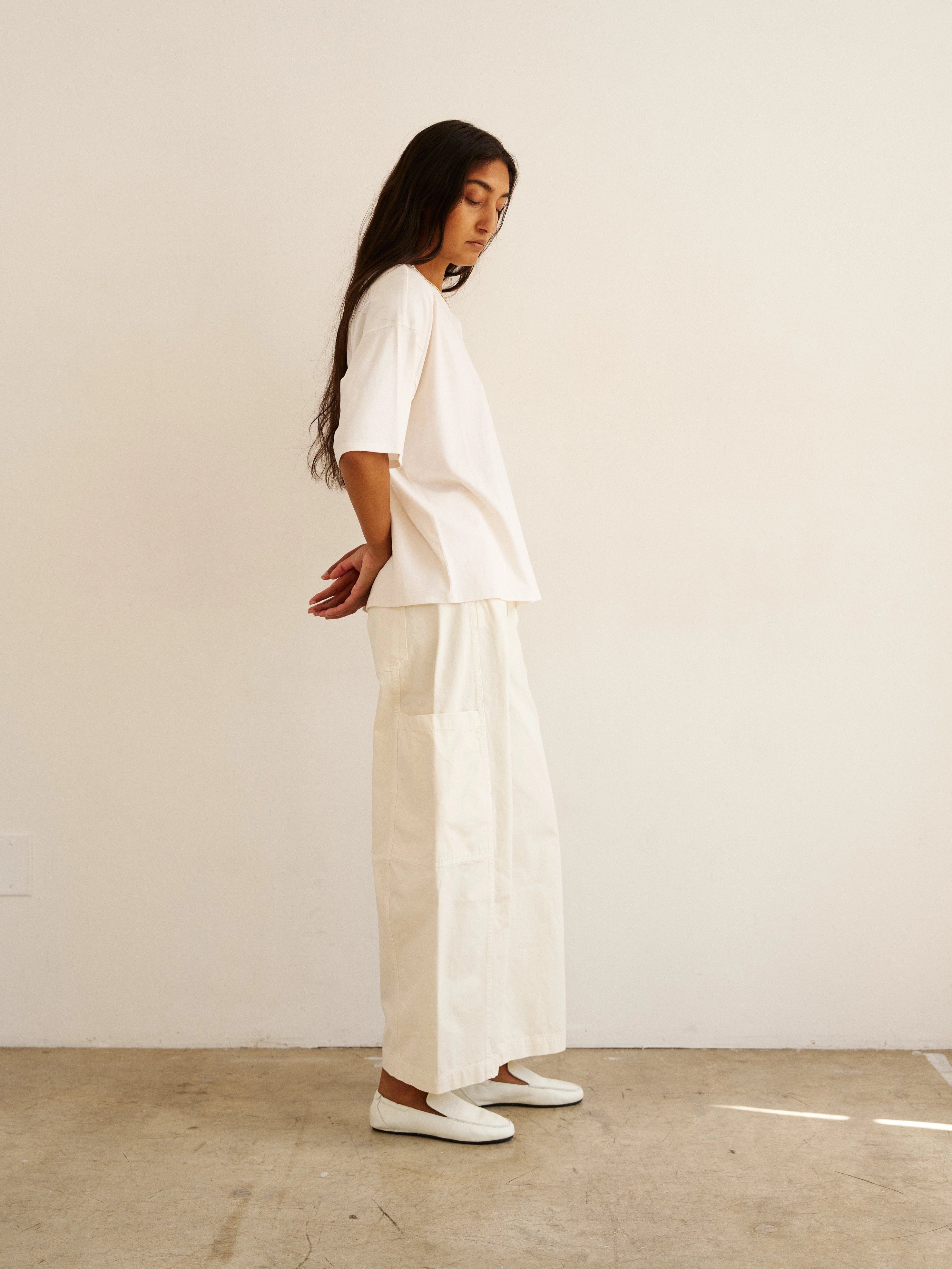 Person wearing a white outfit standing against a plain background