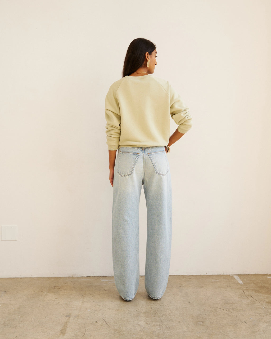 Back view of model wearing Jamie Haller Fan Jean in light stone with a high-rise tapered fit and vintage-inspired wash.