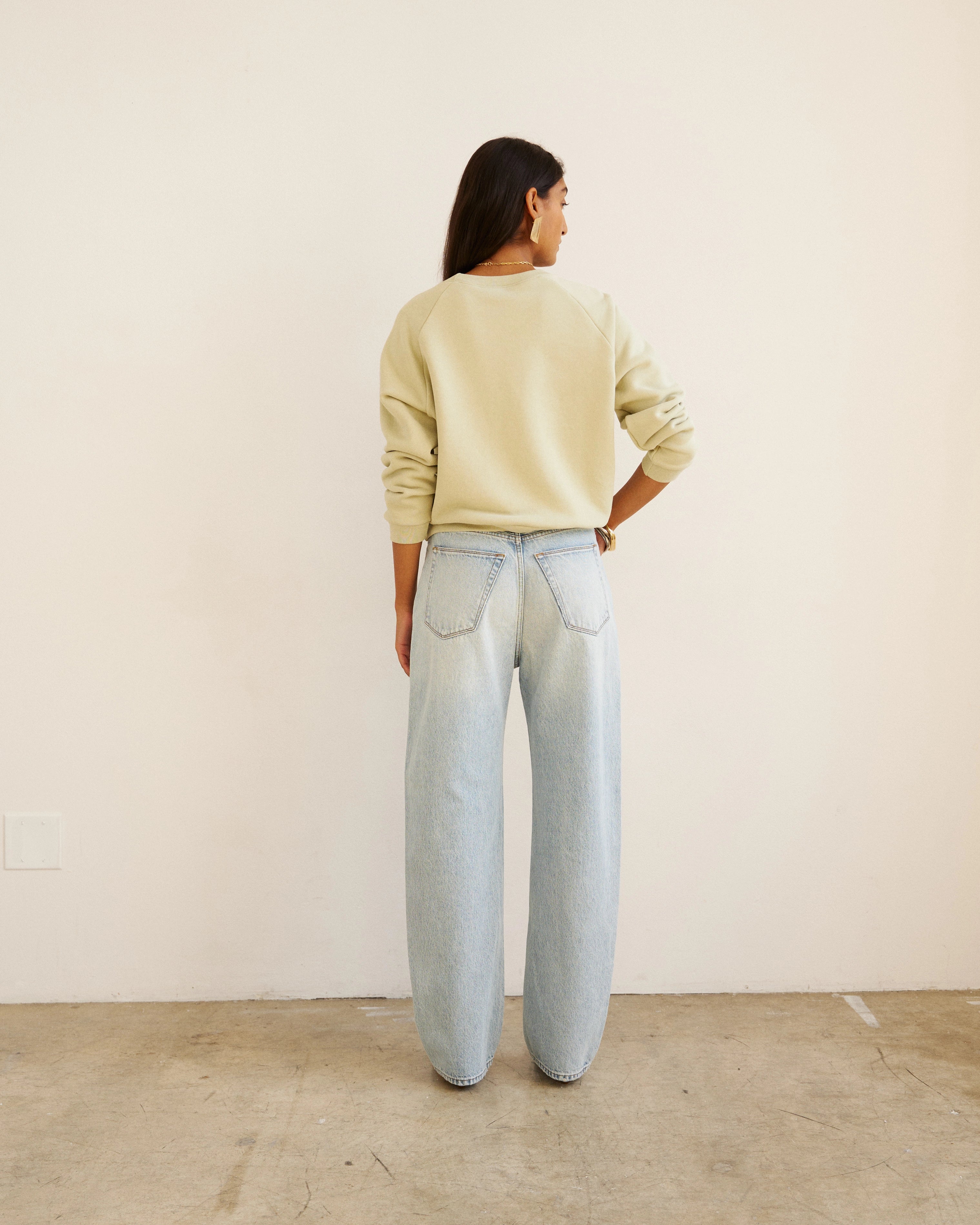 Back view of model wearing Jamie Haller Fan Jean in light stone with a high-rise tapered fit and vintage-inspired wash.