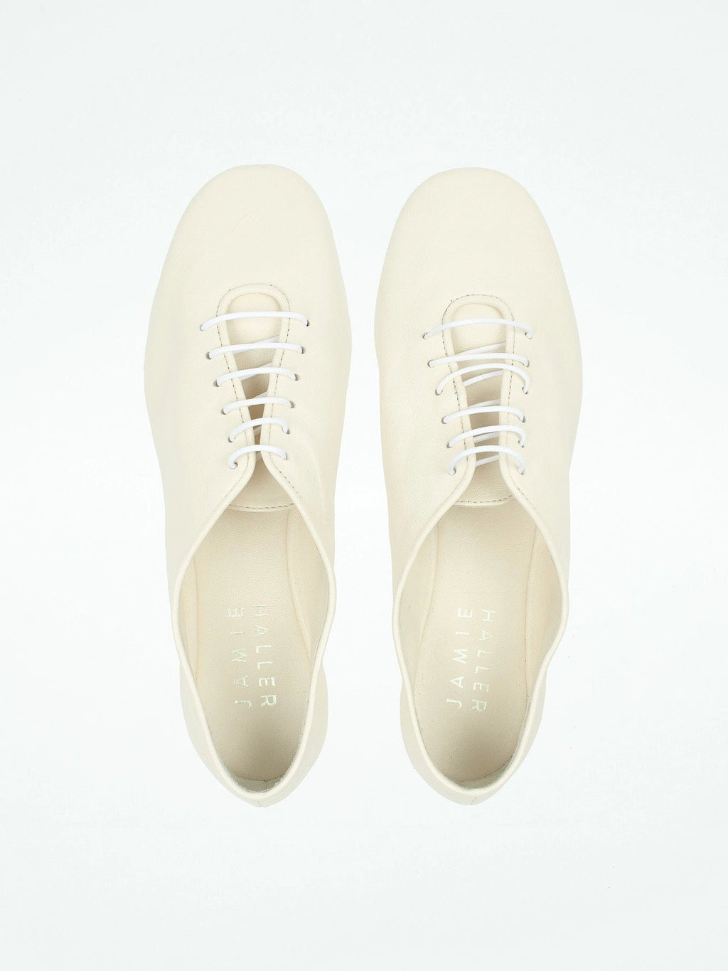 Pair of white sneakers on a light gray background